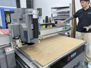 Side-by-side comparison of die-less digital cutter and traditional die-cutting machine for cardboard packaging