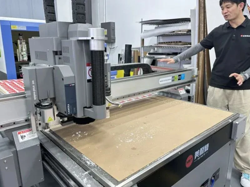 Side-by-side comparison of die-less digital cutter and traditional die-cutting machine for cardboard packaging