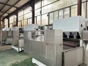 Five-axis CNC router with a curved composite workpiece on the table, ready for trimming