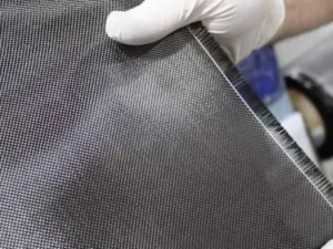 Five-axis CNC machine trimming a cured carbon fiber composite panel with a smooth, delamination-free edge