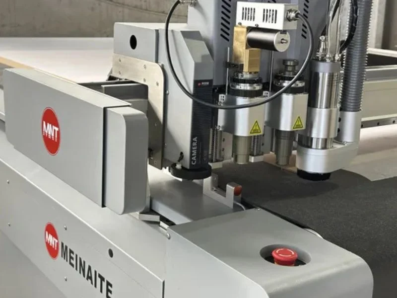 Close-up of multi-tool cutting head with oscillating knife, creasing wheel, V-cut tool and kiss-cut capability
