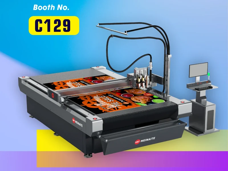MNT MEINAITE digital cutting machine cutting a printed poster, shown with PRINTING United Expo 2026 booth number C129
