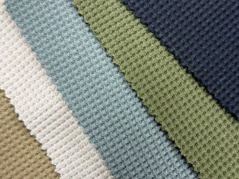 Camera-registered cut of a checked upholstery fabric on the MNT C-series knife table