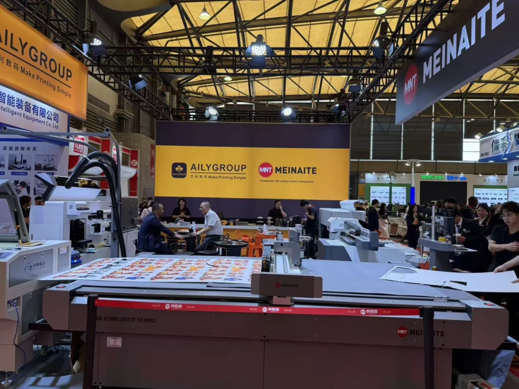 MNT MEINAITE stand in Hall W2 at SIGN CHINA 2026 Shanghai with a C2516T digital cutting table loaded with printed graphics
