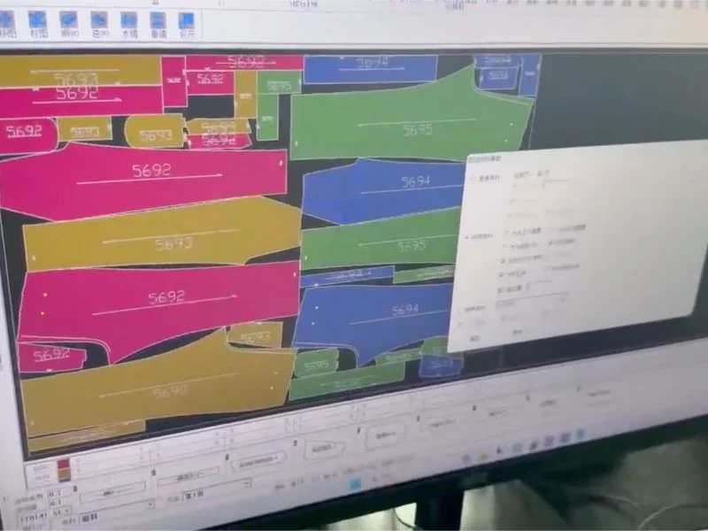 Auto-nesting software screen showing pattern pieces laid out with material utilisation